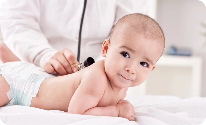 A baby is being examined by an adult.